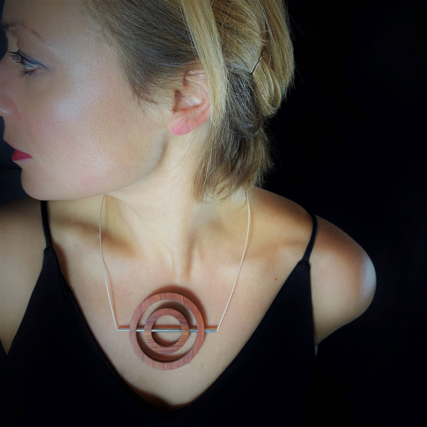 Model wearing the unique and contemporary vegan Iris wood Concentric Circle and silver Tube Necklace by Silverwood Jewellery