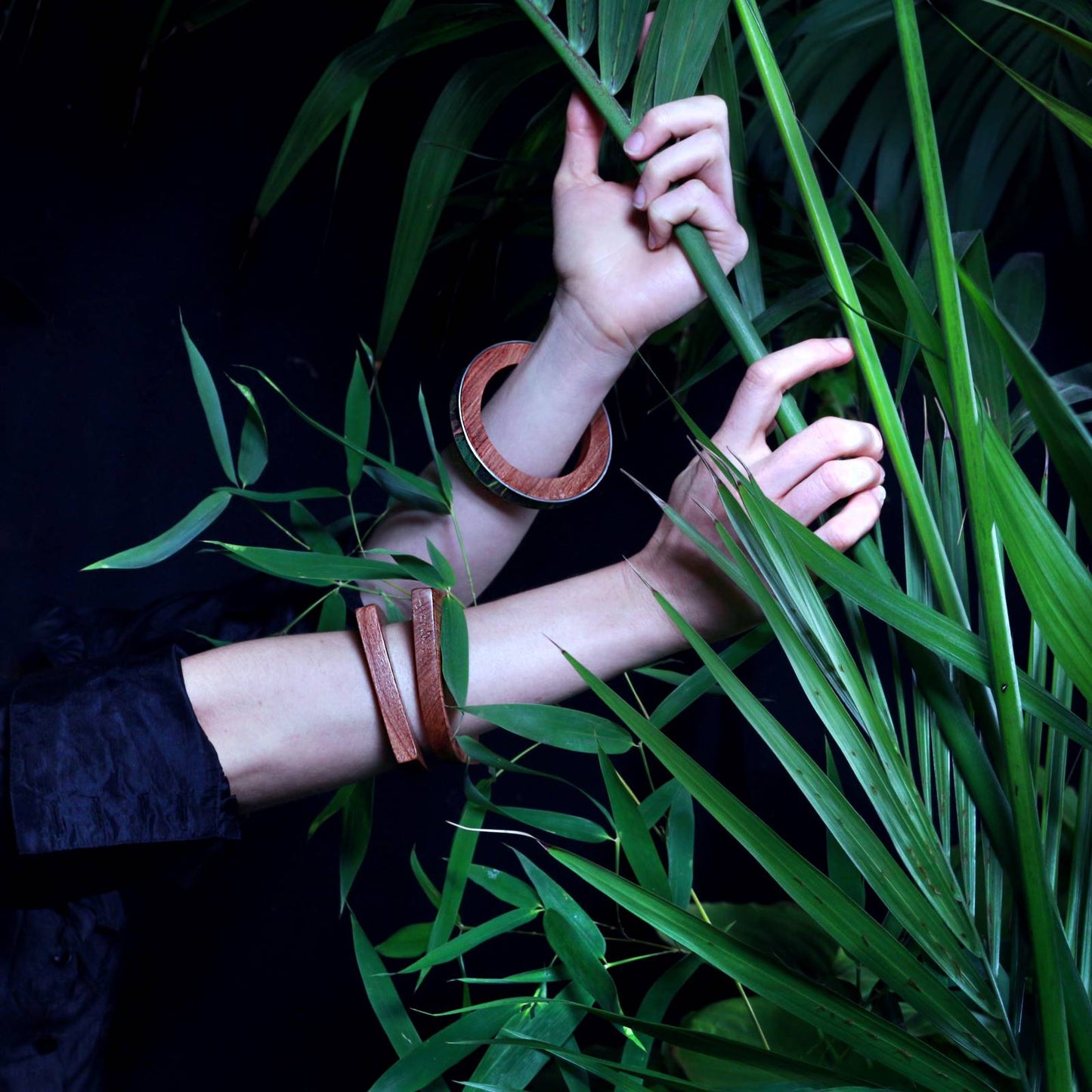 Hands wearing wooden bangles natural vegan polish and the Iris wood and silver handcrafted bangle by Silverwood