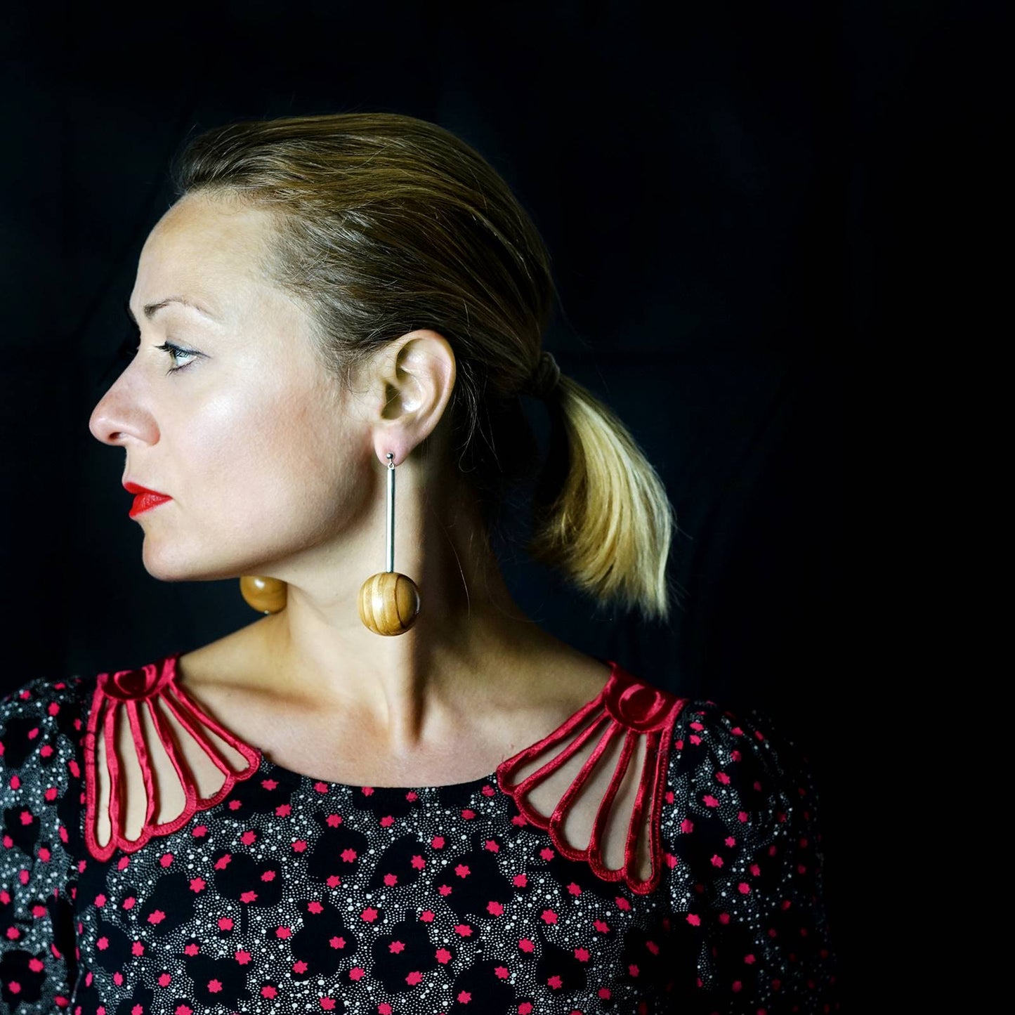 Model wearing Silverwood's long Gaia earrings made from large wood bead and silver tube in light wood vegan earrings