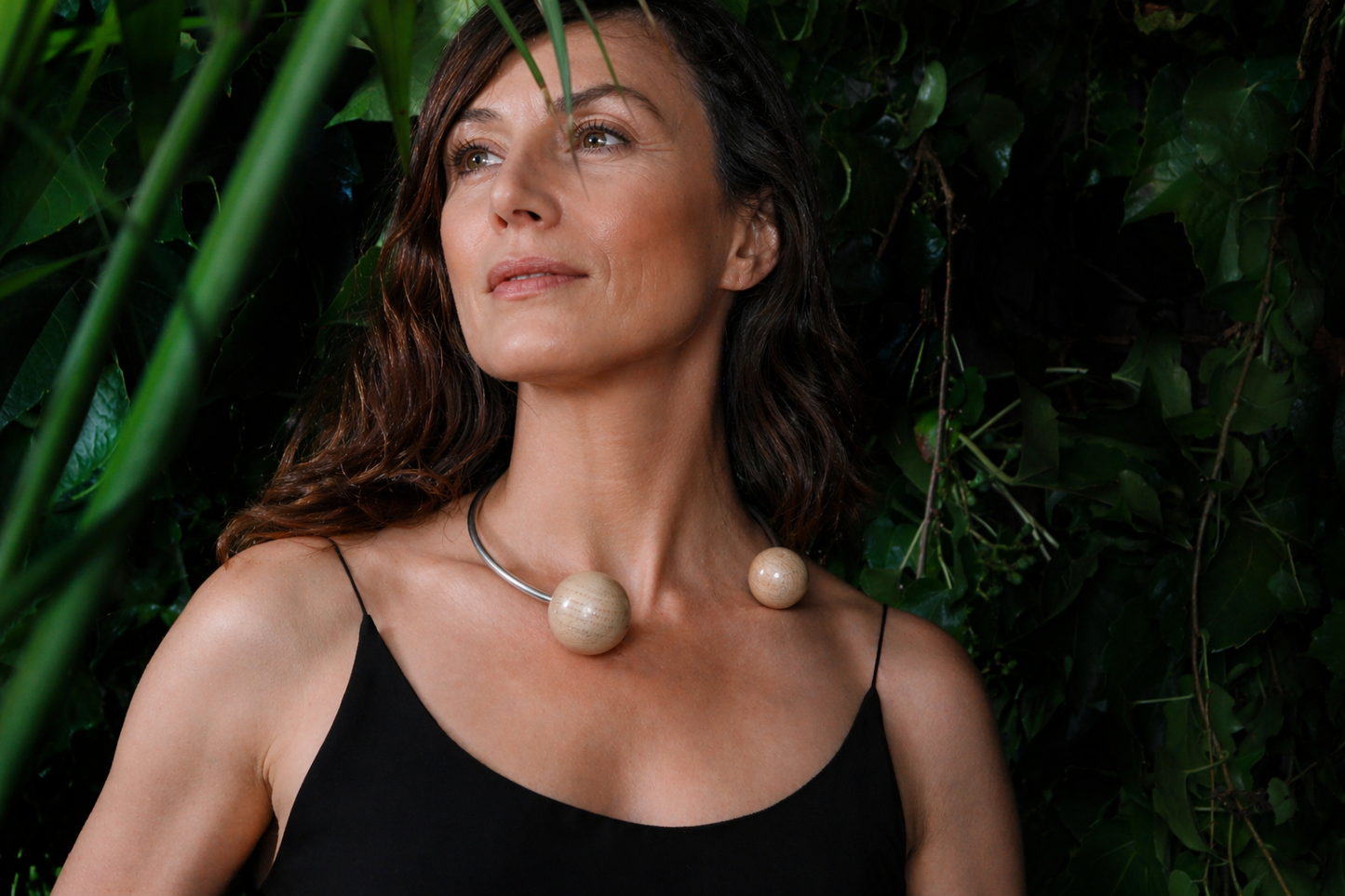 woman over 40 wearing bold silver and wood necklace