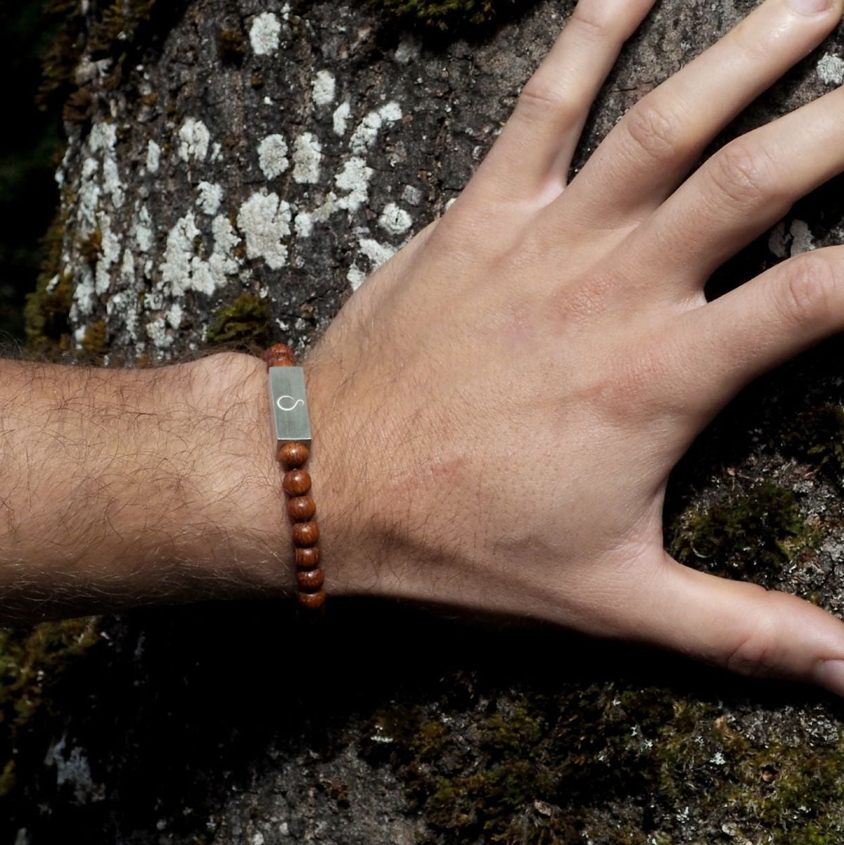 Hand wearing a bracelet on a textured rock surface
