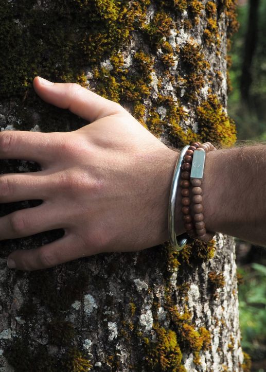 Hand with bracelets on a tree trunk