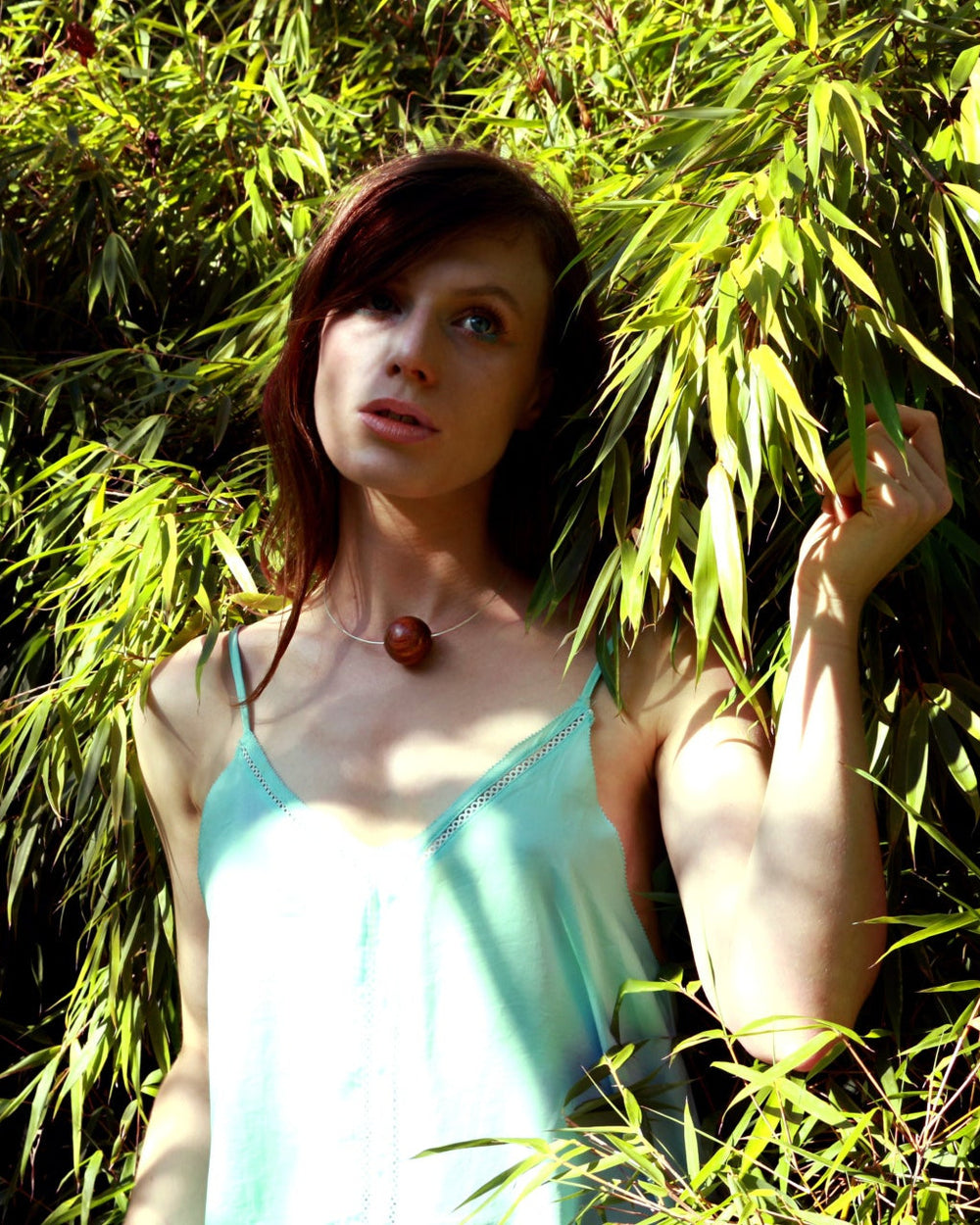 woman amongst leaves wearing a silver and wood necklace by silverwood