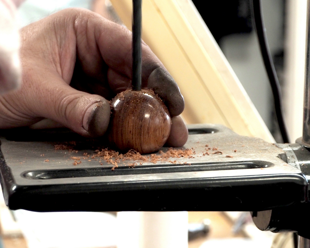 Woodturner shaping bubinga wood bead for Silverwood jewellery, England