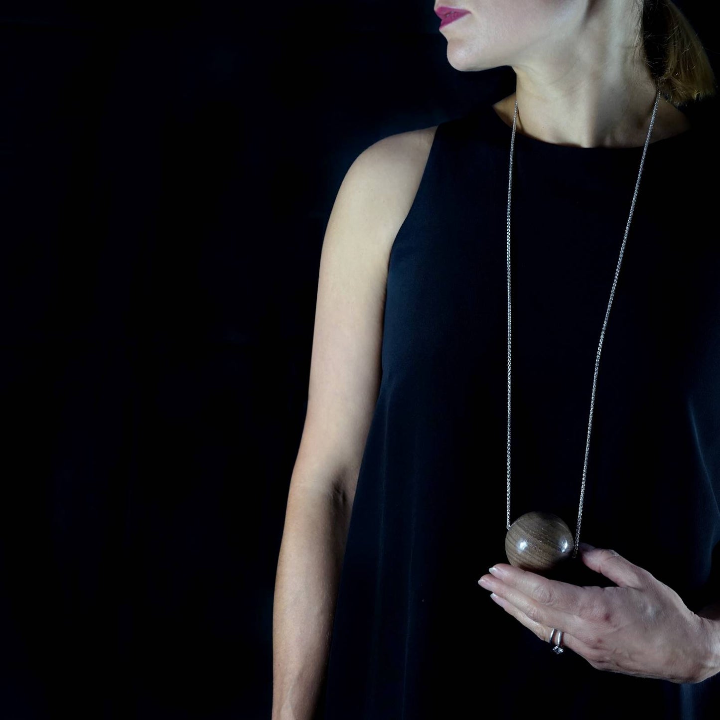 Model wearing the modern Long Gaia sterling silver necklace with giant wooden bead by Silverwood Jewellery