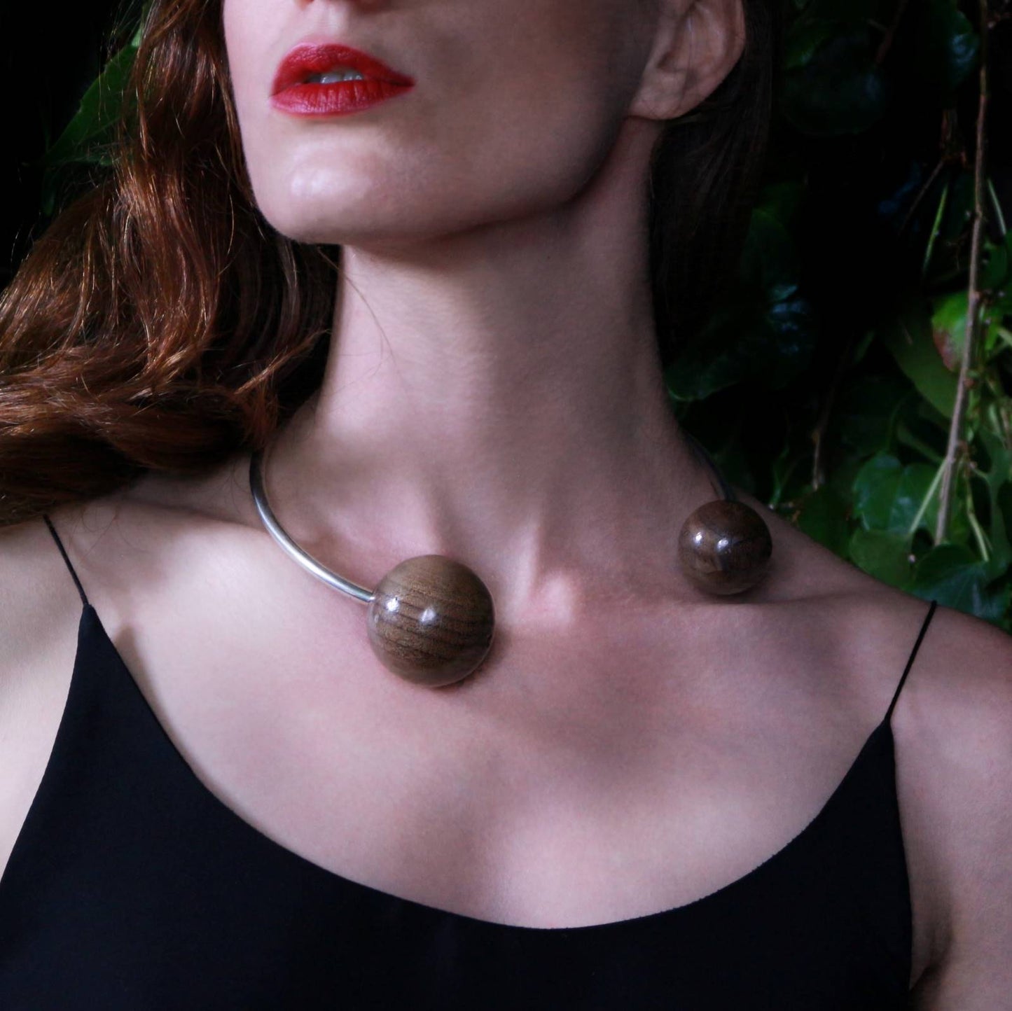 Load image into Gallery viewer, Model wearing the Gaia Double Sphere Torque Necklace by Silverwood Jewellery with large wooden spheres beads in walnut and sterling silver torque necklace

